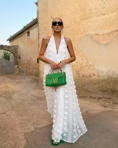 Détail d'une robe longue blanche dos nu avec des appliques florales 3D élégantes