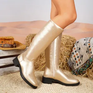 Goldene kniehohe Damenstiefel im eleganten britischen Stil in einer Wüstenszenerie