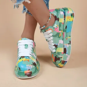 Detailed view of colorful graffiti print platform sneakers for women with white laces.