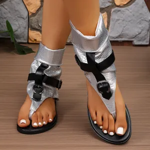 Detailansicht der silbernen Zehentrenner-Sandalen mit Schlangenmuster und schwarzen Schnallenriemen