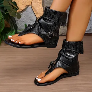 Detaillierte Ansicht schwarzer Gladiatorensandalen mit Krokoprägung und Schnallen an den Füßen