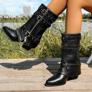 Close-up of black pointed toe boots with buckle straps and chunky heels