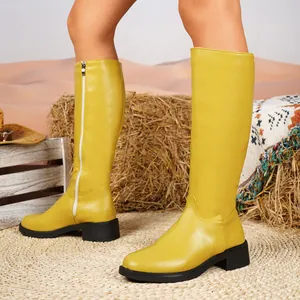 Stylische gelbe kniehohe Stiefel mit Blockabsatz und seitlichem Reißverschluss in der Wüste