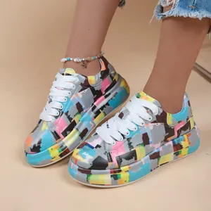 Detailed view of women's colorful graffiti print platform sneakers with white laces.