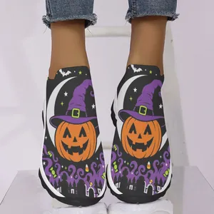 Vue détaillée du motif citrouille et chapeau de sorcière sur baskets en maille pour femme.