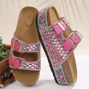 Detail shot of pink rhinestone slides with double buckles and cork platform soles