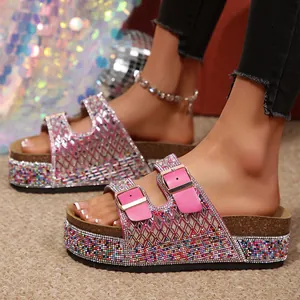 Detail view of pink rhinestone platform sandals with double gold-tone buckles and cork sole.
