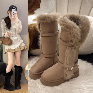 Detail of stylish brown high-top fur snow boots with platform sole and buckle strap