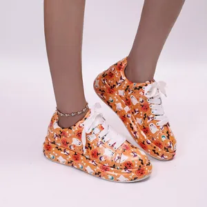 Detailed view of Halloween pumpkin graffiti on women's thick-soled platform sneakers