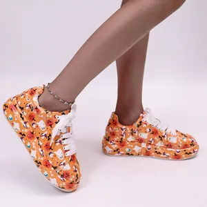 Detail view of women's thick-sole sneakers featuring Halloween pumpkin and ghost prints