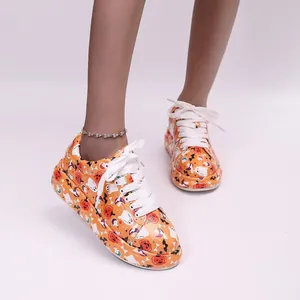 Close-up of vibrant Halloween pumpkin and ghost pattern platform sneakers with laces