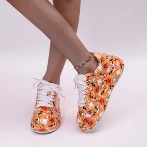Detail view of Halloween pumpkin and ghost pattern sneakers with thick soles.