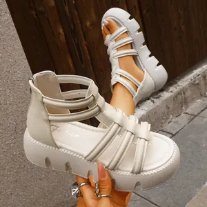 Close-up van beige platform gladiatorsandalen met dikke profielzool en kooiontwerp