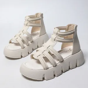 Detailopname van witte platform gladiatorsandalen met bandjes en een dikke plateauzool.