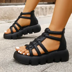 Detailweergave van zwarte Romeinse platformsandalen met ritssluiting achter en leren riempjes