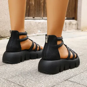 Detailweergave van zwarte gladiator sandalen met plateauzool en rits aan de achterkant