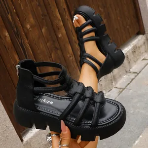 Gedetailleerd overzicht van zwarte platform Romeinse sandalen met getextureerde bandjes