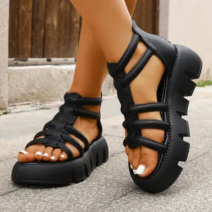 Close-up van zwarte platform gladiatorsandalen met dikke zolen aan een model