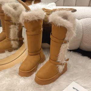 Detail view of tall camel snow boots featuring plush fur trim and buckle straps