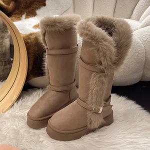 Detailed view of tall snow boots with faux fur trim and buckles on platform soles.