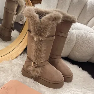 Close-up of stylish tall brown snow boots with thick faux fur trim and platform soles.