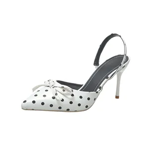 Elegantes zapatos de tacón tipo slingback con lunares blancos y detalle de lazo