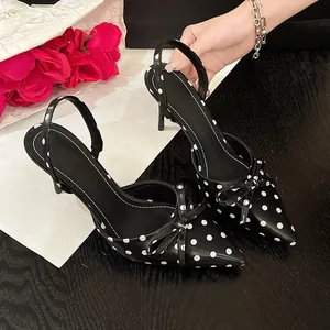 Vista detallada de los tacones destalonados de lunares negros estilo francés con lazo