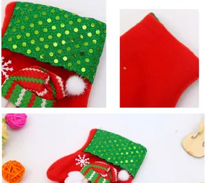 Macro detail of a festive red Christmas stocking featuring green sequins and a plush elf hat