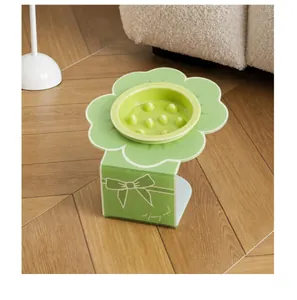 Detailopname van groene bloemvormige voerbak met verhoogde acryl standaard
