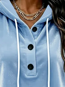 Close-up of light blue velvet hoodie showing buttons, drawstrings and soft texture
