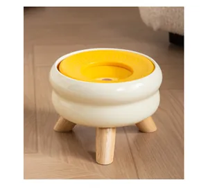 Detailweergave van de moderne keramische drinkbak voor huisdieren met houten poten en gele vlotter