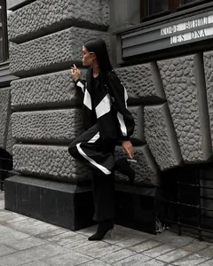 Chic black and white patchwork tracksuit set for women in urban street setting