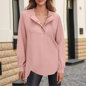 Detailweergave van de roze damestop met lange mouwen en een Henley-hals met knopen.