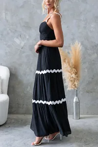 Vue latérale d'une robe maxi noire à étages avec bordure festonnée blanche et fines