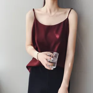 Dettaglio di una canotta in raso bordeaux con spalline sottili indossata da una modella.