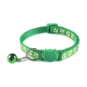 Detail van een groene kattenhalsband met pootafdrukken en een kattenkop veiligheidsgesp
