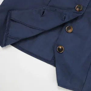 Detailed macro view of navy blue cotton-linen sleeveless vest showing brown tortoiseshell buttons