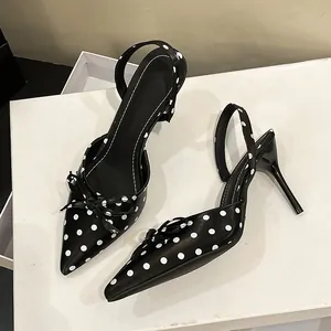 Primer plano elegante de zapatos negros de lunares con un detalle de lazo delicado