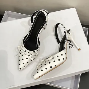 Detalle de elegantes zapatos de tacón blancos con lunares estilo francés y lazo decorativo