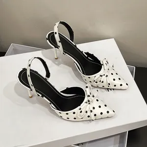 Detalle de tacones destalonados franceses con lunares blancos y un lazo elegante