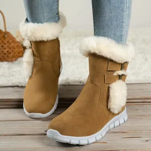 Detail of women's thick-soled snow boots with white faux fur trim and pom-poms