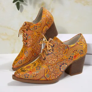 Dettaglio di scarpe décolleté rétro in raso ricamato con lacci, tacco largo e punta.