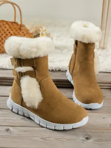 Detailed macro view of women's plush snow boots with thick soles and faux fur lining.
