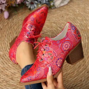 Vista dei dettagli delle scarpe in raso rosso con ricamo floreale e lacci vintage