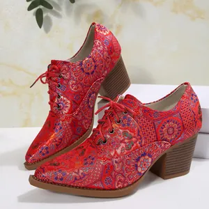 Dettaglio di décolleté vintage in raso rosso ricamato con lacci, tacco largo e punta