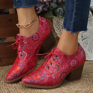 Dettaglio delle décolleté in raso rosso ricamato con tacco largo stile vintage