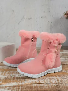 Side view detail of pink faux suede women's snow boots with fur trim and gold buckles