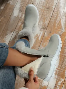 Close-up detail of women's grey snow boots with warm plush lining and side zipper