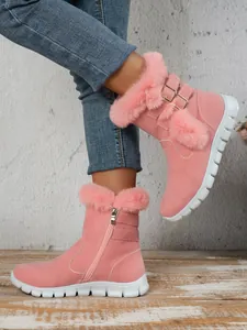 Detail of pink fur-trimmed snow boots with thick white soles and decorative buckle.