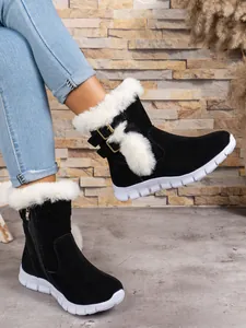 Detailed view of black women's snow boots with white fur trim and metallic buckles